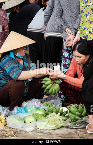 Gruppo di donna vietnamita acquisto al coltivatore outdoor mercato al Vietnam campagna, mercato tradizionale al mattino, cibo sul terreno della strada Foto Stock