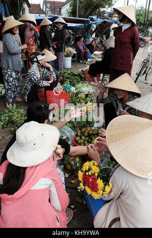 Gruppo di donna vietnamita acquisto al coltivatore outdoor mercato al Vietnam campagna, mercato tradizionale al mattino, cibo sul terreno della strada Foto Stock