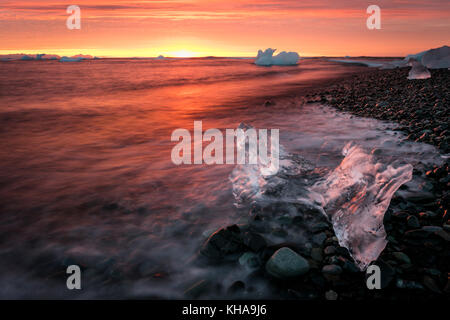 Growler sulla spiaggia al tramonto, Jökulsárlón, Islanda Foto Stock