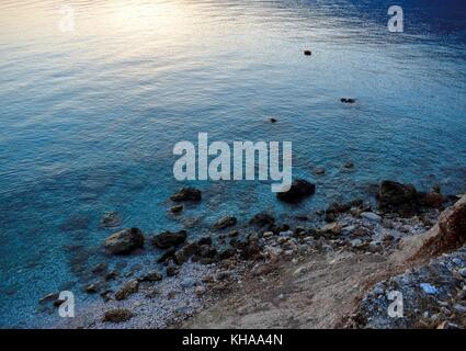 L'acqua blu turchese viene rivelata dall'alba sulla spiaggia di Vouti, Cefalonia, Grecia Foto Stock