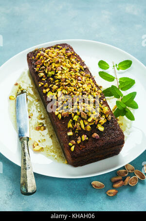 Torta, tea focaccia con yogurt, il cardamomo e i pistacchi . su sfondo blu Foto Stock