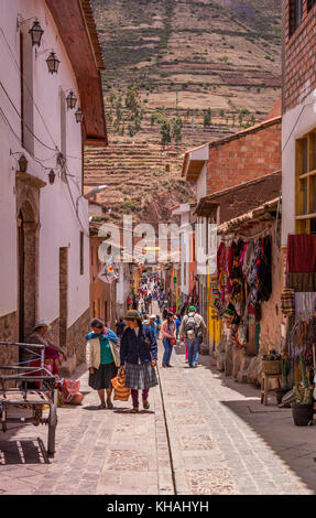 Il Perù la gente del posto e i turisti shop lungo una stretta strada coloniale di Pisac, Pisaq, Perù, Valle Sacra, Sud America. Foto Stock