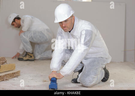 La pavimentazione dei lavoratori al sito in costruzione Foto Stock