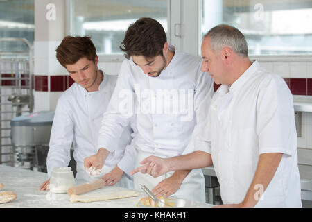 Sorridenti cuochi rendendo chausson francese Foto Stock