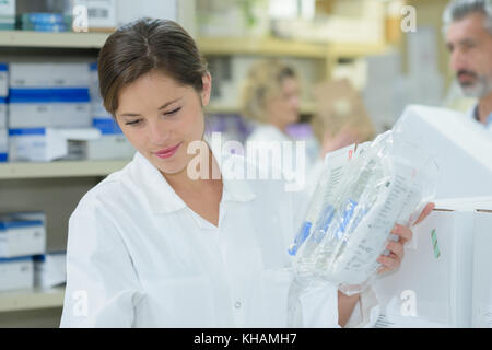 Sorridente al farmacista che lavorano in farmacia Foto Stock