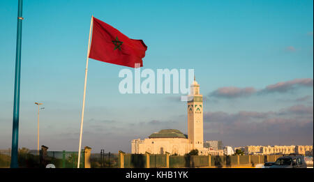 Vista la famosa moschea di Hassan II e una sventola bandiera marocchino contro sky - Casablanca - Marocco Foto Stock
