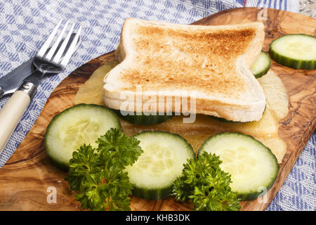 Pane tostato con fuso irlandese e mite di formaggio cheddar bianco e fette di cetriolo Foto Stock