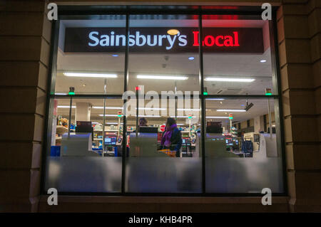 Guardando attraverso la finestra di un Sainsburys locale con self service casse late night shopping in Bath Regno Unito Foto Stock