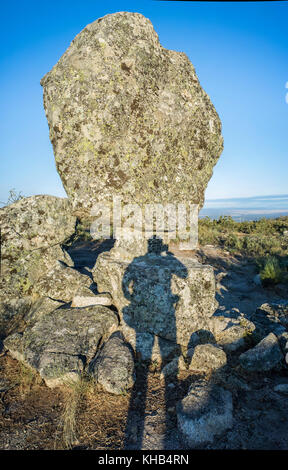 Ombra di un fotografo che scatta El Cancho que se menea. Famoso monumento megalitico di Montanchez, Caceres, Spagna Foto Stock