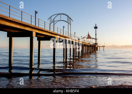 Tramonto a la spiaggia di Brighton, mostrando il molo di cemento che ha funzioni astratte. Foto Stock