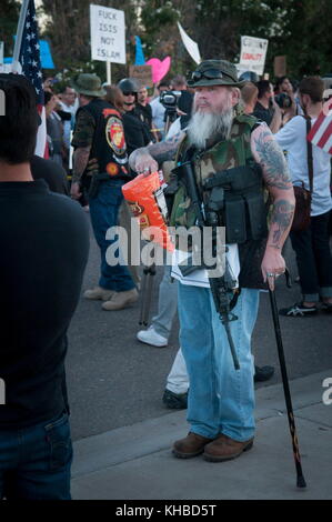 Phoenix, Arizona, Stati Uniti. 10 marzo 2015. Il protestatore anti-islamico DON, (nessun cognome dato), offre croste di maiale ai compagni manifestanti mentre manifestano contro la fede, nonché i loro diritti di secondo emendamento di possedere e portare armi da fuoco durante una protesta del Centro comunitario islamico di Phoenix. L'evento avrebbe dovuto essere una gara di "estrazione di Maometto” fuori dalla moschea presso il di un ex Marine degli Stati Uniti che, secondo quanto riferito, si tratta di un esercizio di libertà di parola. Non si è svolta alcuna competizione. Secondo quanto riferito, la moschea è il luogo di culto di due uomini armati che hanno attaccato un evento simile a Garland, Texas, o Foto Stock