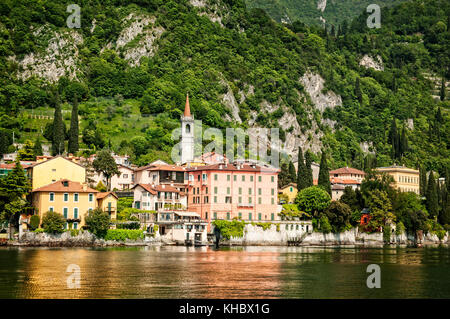 La basilca torre campanaria di Varenna si erge sopra la città lungo la sponda orientale del lago di Como, Italia. Foto Stock