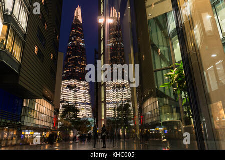 La Shard e i suoi riflessi in ufficio blocchi lungo più Londra Riverside sulla riva sud del fiume Tamigi al crepuscolo, Londra Foto Stock