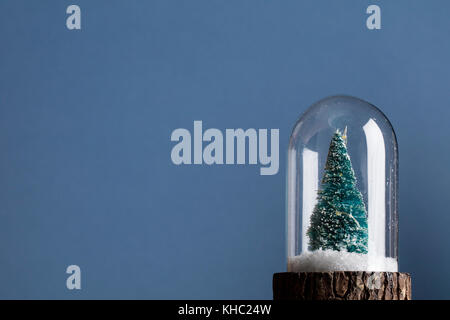 Festa di Natale scena. Albero di natale all'interno di un vetro snowglobe Foto Stock