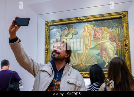 Firenze, Italia - Ottobre 31st, 2017: l uomo si prende un selfie davanti la nascita di Venere di Botticelli alla galleria degli Uffizi di Firenze, Toscana, Italia Foto Stock