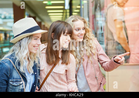 Il gruppo di amici di sesso femminile shopping davanti alla vetrina di un negozio Foto Stock