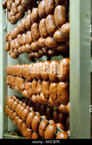 Deliziose salsicce affumicate sullo sfondo di una fabbrica di carne Foto Stock