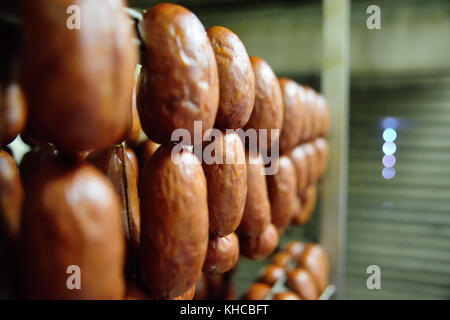 Deliziose salsicce affumicate sullo sfondo di una fabbrica di carne Foto Stock