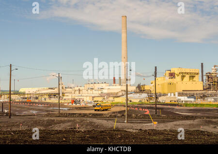 Maggiori produttori di petrolio grezzo sintetico da sabbie dell'olio. in background pipe e scuola bus sulla parte anteriore Foto Stock