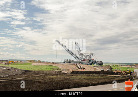 Attrezzature pesanti per oil sands industria, rosso e gru enorme digger scavare il terreno per i tubi Foto Stock