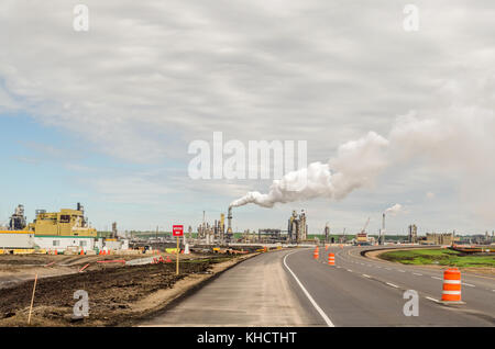 Maggiori produttori di petrolio grezzo sintetico da sabbie dell'olio. oil sands. in background, parcheggio in primo piano, pipe Foto Stock