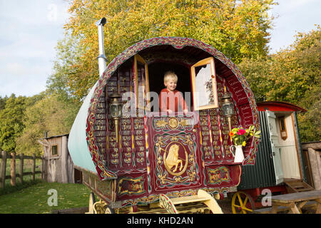 Ragazzo che guarda fuori dalla porta della tradizionale gypsy caravan Foto Stock