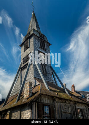 La storica torre dell'orologio in Honfleur Francia famosa per la sua facciata di ardesia edifici contro un nuvoloso cielo blu Foto Stock