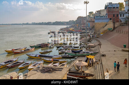 Vista aerea di varanasi gange fiume ghat con antiche strutture architettoniche templi e variopinte barche di legno. Foto Stock