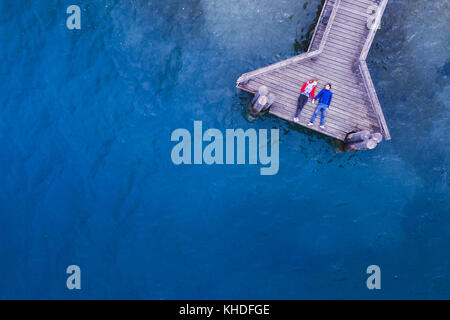 Coppia romantica giacente sul molo in legno sul lago con acqua blu, amore e concetto di datazione, sfondo con copyspace Foto Stock