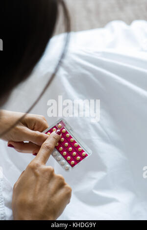 Donna che mantiene il controllo delle nascite pillole Foto Stock