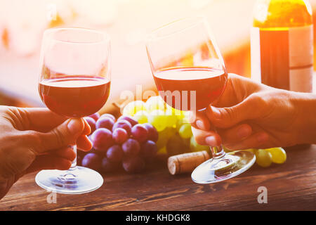 La gente beve vino insieme, saluti a due mani tenendo gli occhiali Foto Stock