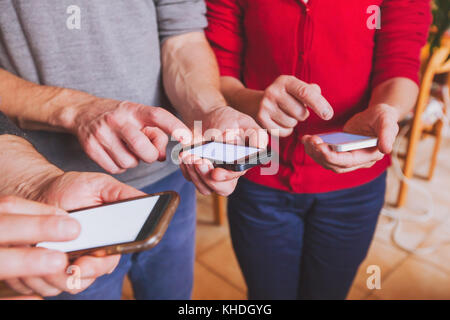 Le mani di persone che utilizzano smartphone, online o di comunicazione sociale il concetto di rete Foto Stock