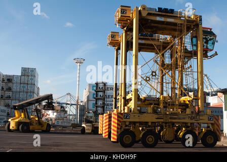 Auckland, Nuova Zelanda - 17 aprile 2012: noell straddle carrier e la pila di contenitori al porto di Auckland. Foto Stock