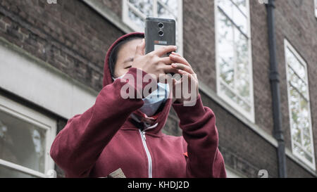 Londra, Regno Unito. Xv nov, 2017. uno studente cinese registra i momenti dal suo telefono cellulare durante una manifestazione studentesca contro le tasse e tagli su 15 Novembre, 2017 a Londra . gli studenti universitari insieme con il lavoratore dimostrare al Westminster. Credito: ioannis alexopoulos/Pacific press/alamy live news Foto Stock