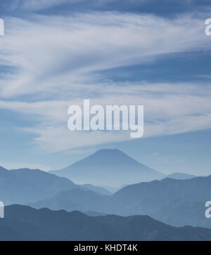 Iconico monte Fuji avvolto in misty nuvole come e vecchio dipinto, visto dal monte takao in Giappone Foto Stock