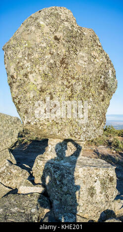 Ombra di un fotografo che scatta El Cancho que se menea. Famoso monumento megalitico di Montanchez, Caceres, Spagna Foto Stock