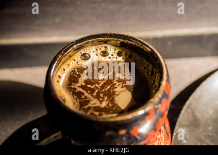 Close up vintage nero e rosso la tazza con il caffè Foto Stock