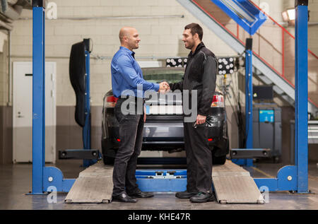 Meccanico e il cliente si stringono la mano a car service Foto Stock