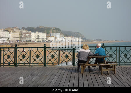 Giovane seduto sul molo di Hastings, East Sussex Foto Stock