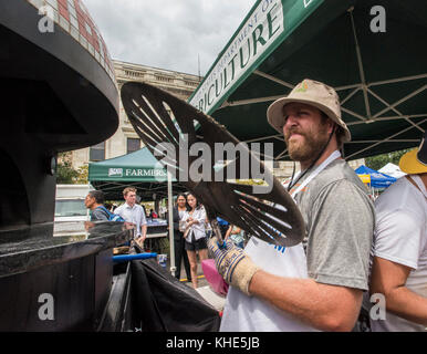 La società di pizza del legname è aperta per il commercio con il co-proprietario Chris Brady che manning il forno mobile del mattone al reparto degli Stati Uniti di Agricoltura (USDA) Farmers Market and Farmers Market Night a Washington, D.C., il venerdì 5 agosto 2016. Utilizza una buccia di metallo a causa dell'impasto extra appiccicoso che fanno con prodotti biologici freschi dal Tuscarora Organic Growers (TOG) Pennsylvania produrre hub. Da lì, TOG soddisfa gli ordini dei clienti della zona di Washington, come Timber Pizza Company che utilizza il basilico per la salsa al pesto e la guarnitura, pomodori per la salsa, e mais, funghi, zucchine, fiori di zucca e m. Foto Stock