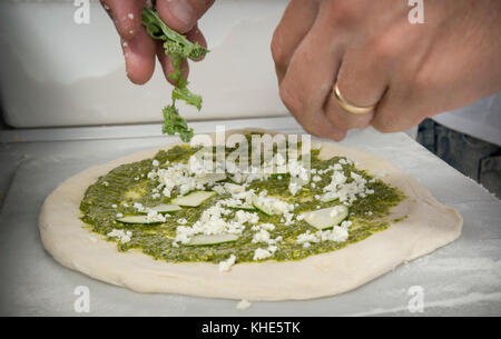 Il Jason Kellogg della Società di pizza del legno getta l'impasto alto all'interno di una tenda del venditore del Dipartimento dell'Agricoltura degli Stati Uniti (USDA) ad esso il mercato agricolo dell'USDA, a Washington, D.C., venerdì 5 agosto 2016. Il nativo di Washington Andrew Dana e il locale Chris Brady di Annapolis sono co-proprietari della Timber Pizza Company che dice che durante una calda giornata estiva come questa spesso servono più di 260 pizze durante le 4 ore di mercato di metà giornata, e pizze aggiuntive durante il mercato serale degli agricoltori USDA. Popolarità e redditività possono venire in parte al loro uso di Tuscarora Organic Growers (TOG) che dicono, h. Foto Stock