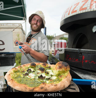 Il Jason Kellogg della Società di pizza del legno getta l'impasto alto all'interno di una tenda del venditore del Dipartimento dell'Agricoltura degli Stati Uniti (USDA) ad esso il mercato agricolo dell'USDA, a Washington, D.C., venerdì 5 agosto 2016. Il nativo di Washington Andrew Dana e il locale Chris Brady di Annapolis sono co-proprietari della Timber Pizza Company che dice che durante una calda giornata estiva come questa spesso servono più di 260 pizze durante le 4 ore di mercato di metà giornata, e pizze aggiuntive durante il mercato serale degli agricoltori USDA. Popolarità e redditività possono venire in parte al loro uso di Tuscarora Organic Growers (TOG) che dicono, h. Foto Stock