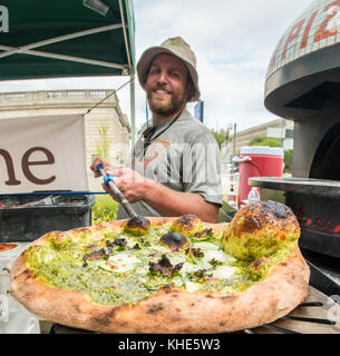 Il Jason Kellogg della Società di pizza del legno getta l'impasto alto all'interno di una tenda del venditore del Dipartimento dell'Agricoltura degli Stati Uniti (USDA) ad esso il mercato agricolo dell'USDA, a Washington, D.C., venerdì 5 agosto 2016. Il nativo di Washington Andrew Dana e il locale Chris Brady di Annapolis sono co-proprietari della Timber Pizza Company che dice che durante una calda giornata estiva come questa spesso servono più di 260 pizze durante le 4 ore di mercato di metà giornata, e pizze aggiuntive durante il mercato serale degli agricoltori USDA. Popolarità e redditività possono venire in parte al loro uso di Tuscarora Organic Growers (TOG) che dicono, h. Foto Stock