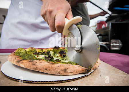 Il Jason Kellogg della Società di pizza del legno getta l'impasto alto all'interno di una tenda del venditore del Dipartimento dell'Agricoltura degli Stati Uniti (USDA) ad esso il mercato agricolo dell'USDA, a Washington, D.C., venerdì 5 agosto 2016. Il nativo di Washington Andrew Dana e il locale Chris Brady di Annapolis sono co-proprietari della Timber Pizza Company che dice che durante una calda giornata estiva come questa spesso servono più di 260 pizze durante le 4 ore di mercato di metà giornata, e pizze aggiuntive durante il mercato serale degli agricoltori USDA. Popolarità e redditività possono venire in parte al loro uso di Tuscarora Organic Growers (TOG) che dicono, h. Foto Stock