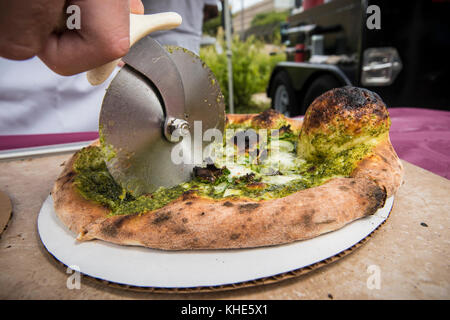 Il Jason Kellogg della Società di pizza del legno getta l'impasto alto all'interno di una tenda del venditore del Dipartimento dell'Agricoltura degli Stati Uniti (USDA) ad esso il mercato agricolo dell'USDA, a Washington, D.C., venerdì 5 agosto 2016. Il nativo di Washington Andrew Dana e il locale Chris Brady di Annapolis sono co-proprietari della Timber Pizza Company che dice che durante una calda giornata estiva come questa spesso servono più di 260 pizze durante le 4 ore di mercato di metà giornata, e pizze aggiuntive durante il mercato serale degli agricoltori USDA. Popolarità e redditività possono venire in parte al loro uso di Tuscarora Organic Growers (TOG) che dicono, h. Foto Stock