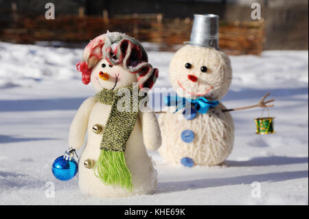 Due pupazzi di neve su sfondo di neve Foto Stock