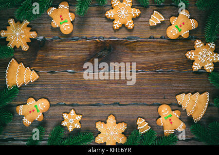 Il natale di panpepato, Abete rami in forma di un telaio in legno marrone background. Composizione di natale. flat laico, vista dall'alto, spazio libero Foto Stock