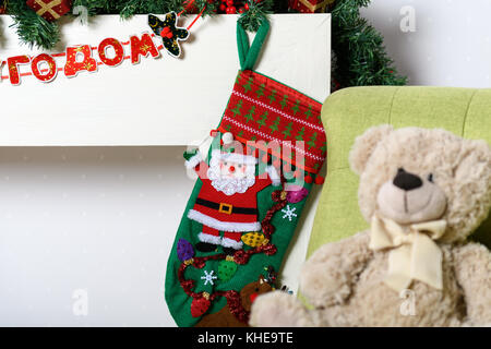 Orsacchiotto di peluche in una sedia sotto l albero di natale Foto Stock