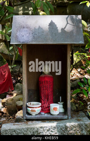 Iga ueno - Giappone, 1 giugno 2017: tradizionale in pietra scolpita con jizo mantello rosso onorati e rispettati con una tazza di acqua e incenso nel Parco di Ueno Foto Stock