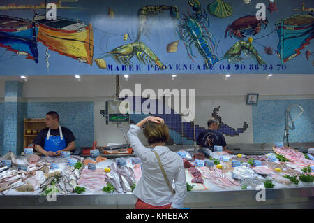 Una donna l'acquisto di pesce fresco a Les Halles il mercato coperto di Avignone, Provenza, Francia Foto Stock
